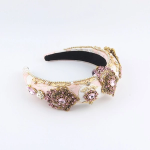 Detailansicht des rosa Barock-Stirnbands mit goldenen Blumenmetallen und Kristallsteinen