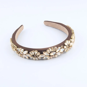 Detail showing champagne crystal floral patterns on a dark brown satin headband base