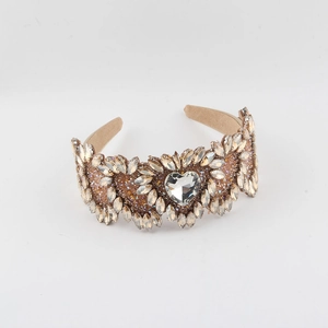 Detail of champagne crystal headband featuring a large heart centerpiece and marquise rhinestones