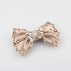 Elegant champagne satin bow hair clip with luxury rhinestone trim and pearl accents