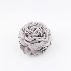 Vista dettagliata del fermaglio per capelli a fiore di camelia in tessuto grigio a strati