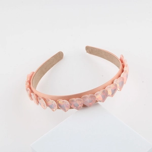 Vista dettagliata di cristalli rosa a forma di cuore su una fascia per capelli in tessuto