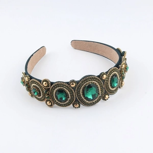 Detailed view of hand-stitched emerald green baroque headband with crystal embellishments