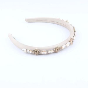 Eleganter beige gepolsterter Haarreif mit funkelnden Strasssteinen und goldenen Blumen