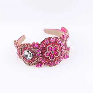 Détail d'un serre-tête baroque rose avec strass et motifs géométriques floraux