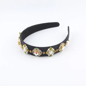 Detail eines Blumen-Haarreifens mit Perlen, Goldblumen und Strass auf schwarzem Satin