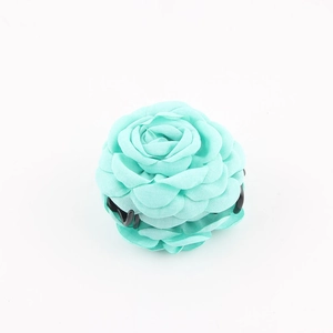 Dettaglio di un fermaglio per capelli a rosa in tessuto verde menta con petali delicati