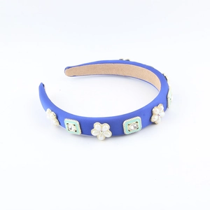 Detailaufnahme blauer Haarreif aus Stoff mit Blumenmotiven und quadratischem Kristallbesatz
