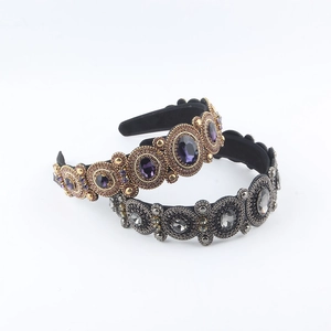 Close-up of Baroque velvet headbands with intricate purple and grey crystal embellishments
