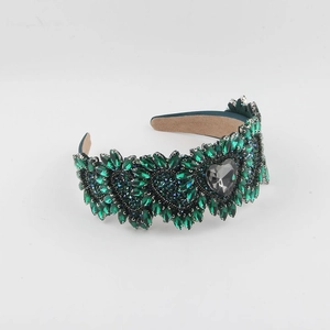 Detailed view of green rhinestone headband with crystal hearts and emerald marquise gems