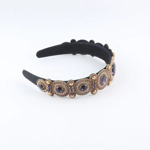 Detailed macro view of baroque headband featuring luxury purple crystals and gold accents