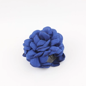 Dettaglio della molletta per capelli a rosa in tessuto blu con petali stratificati e presa