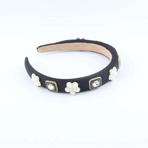 Eleganter schwarzer Haarreif mit weißen Perlblumen und Strasssteinen auf weißem Grund