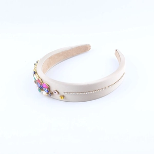 Detail of champagne satin headband with colorful crystal flower and rhinestone accents