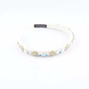 Detail eines handgefertigten Satin-Stirnbands mit Kristallen und Goldblumenperlen