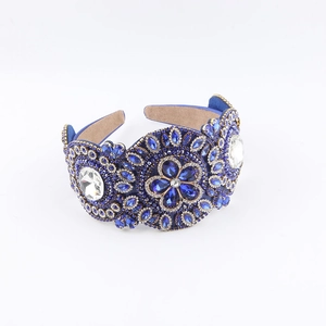 Détail du serre-tête baroque large avec cristaux bleus et motifs floraux strassés