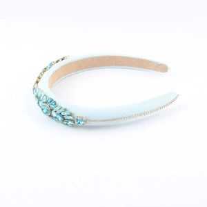Detail of blue baroque headband featuring heavy rhinestones and golden chain trim