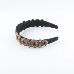 Close-up of Baroque velvet headband with purple crystals and gold vintage metal settings