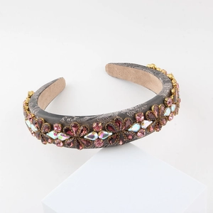 Macro detail of luxury floral headband with purple rhinestones on gray satin fabric