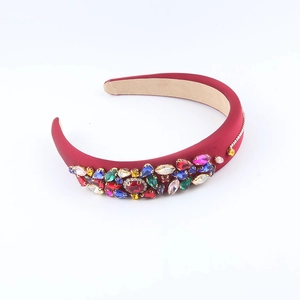 Macro detail of red padded sponge headband with colorful rhinestones and velvet lining
