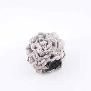 Dettaglio macro della molletta per capelli a rosa grigio fumo con petali in tessuto
