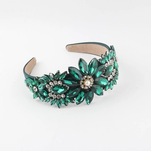 Detail of green gemstone headband featuring floral rhinestone patterns and pearl accents