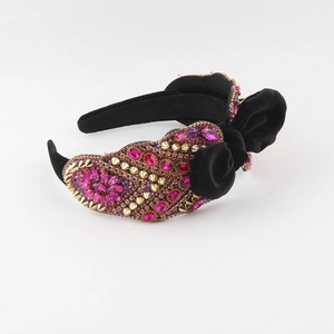 Baroque black velvet headband with pink rhinestones, gold studs, and side bow decoration