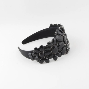 Close-up of luxury Baroque headband with shiny black crystals and ornate floral rhinestones