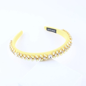 Detail of yellow handmade padded headband with sparkling crystal rhinestone leaf patterns