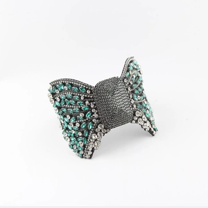 Detailed view of Baroque bow hairband with emerald green and white rhinestones