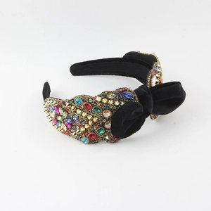 Detailed view of the velvet headband with colorful rhinestones and gold pyramid studs