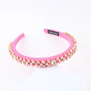 Pink sponge headband for women with sparkling crystal leaf design on white stand