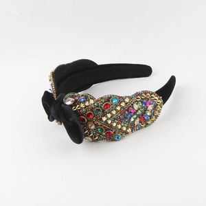 Baroque velvet headband with colorful rhinestones and gold studs on white background