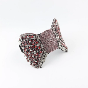 Detail view of large baroque bow headband with red crystals and sparkling rhinestones