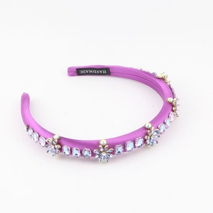 Détail du serre-tête en satin violet rembourré avec fleurs en cristal multicolores