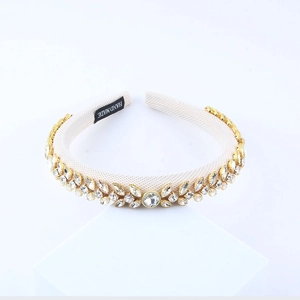 Elegant sponge headband with leaf patterns and sparkling rhinestones on a beige base
