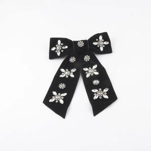 Detail of a black velvet Christmas bow hair clip with sparkling silver rhinestones