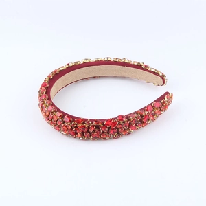 Detailed view of luxury baroque headband with red crystals and gold-tone claw settings