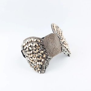 Close-up detail of baroque bow headband featuring champagne and clear crystals on black alloy