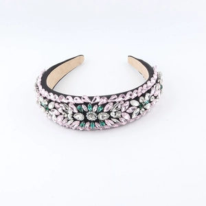 Detailed close-up of pink and green rhinestones on a wide fabric baroque headband