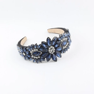 Detail view of the floral rhinestone headband featuring dark blue crystals on fabric