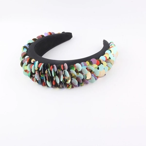 Close-up of bohemian sponge headband featuring vibrant colorful sequins on a black base
