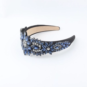 Detailed view of handmade wide headband with blue rhinestone flower patterns and crystals