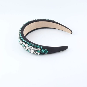 Detail of green and white crystals on a thick black sponge headband with soft inner lining
