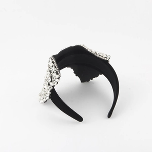 Close-up of black velvet headband with sparkling leaf-shaped crystal rhinestone embellishments