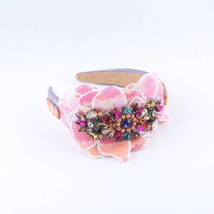 Close-up of pink sequin flowers and multi-colored rhinestones on a baroque headband