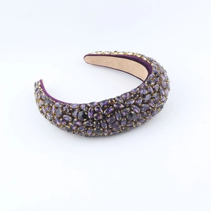 Détail d'un serre-tête en velours violet orné de strass avec sertissage à griffes