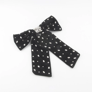 Detail of black velvet bow hair clip with hand-sewn sparkling rhinestones and crystal tassels