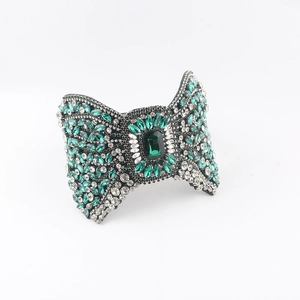 Detail of baroque headband featuring green rhinestones and emerald-cut center stone