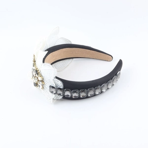 Detail of baroque headband featuring white lace flowers, gray crystals and pearls